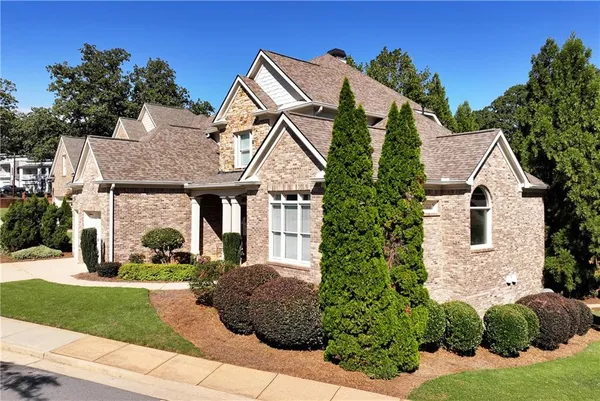 a view of a white house with a yard and potted plants