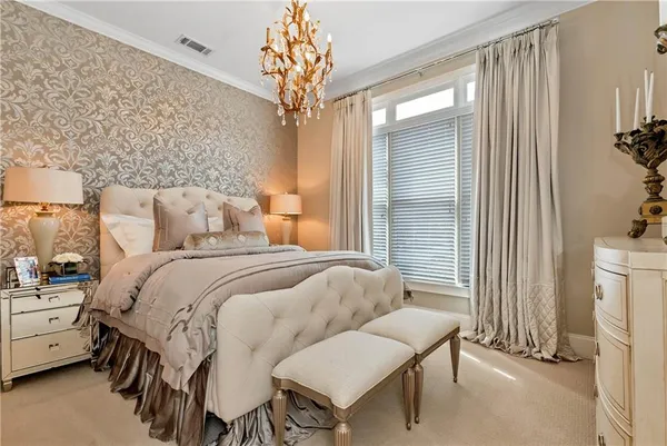a bedroom with a bed chandelier and a window