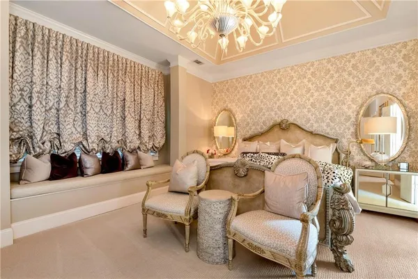 a bedroom with a large bed and a chandelier