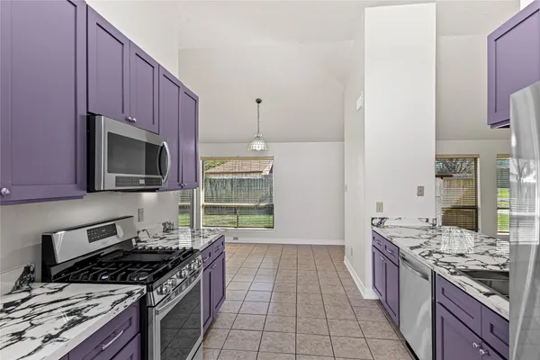 a kitchen with stainless steel appliances a stove a sink and a microwave