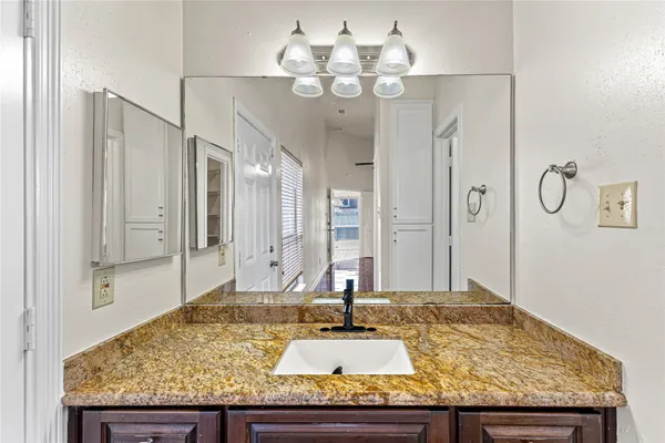 a bathroom with a granite countertop sink and a mirror
