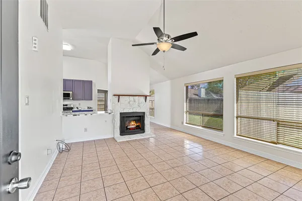 a view of an empty room with a fireplace and a window