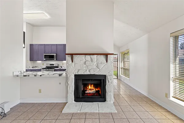 a view of an empty room with a fireplace and a window