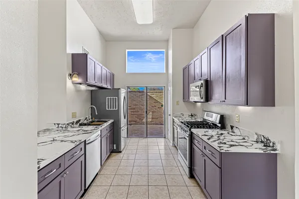 a kitchen with stainless steel appliances a stove top oven and a sink