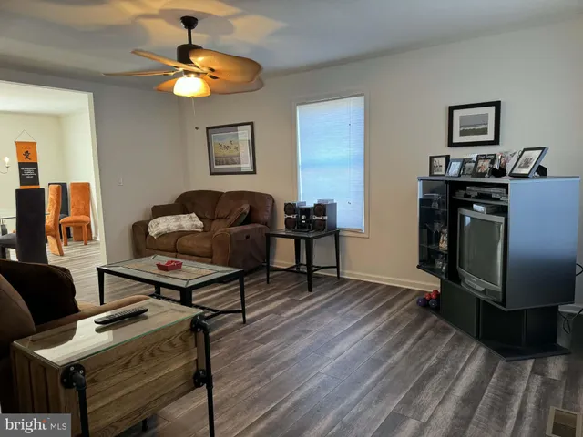 a living room with furniture and a flat screen tv with wooden floor