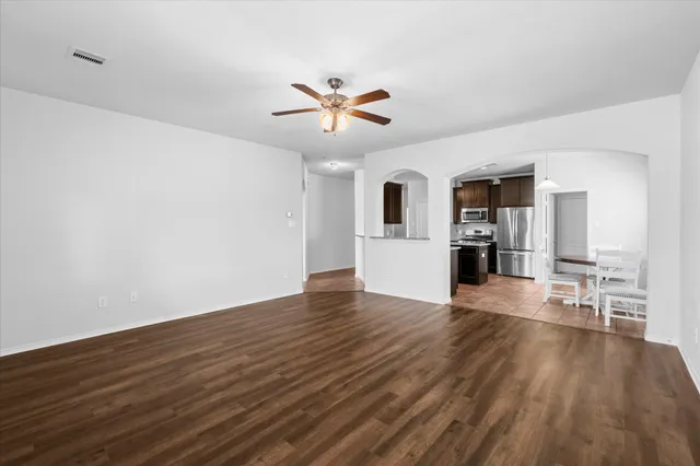 a view of a livingroom with wooden floor and a ceiling fan
