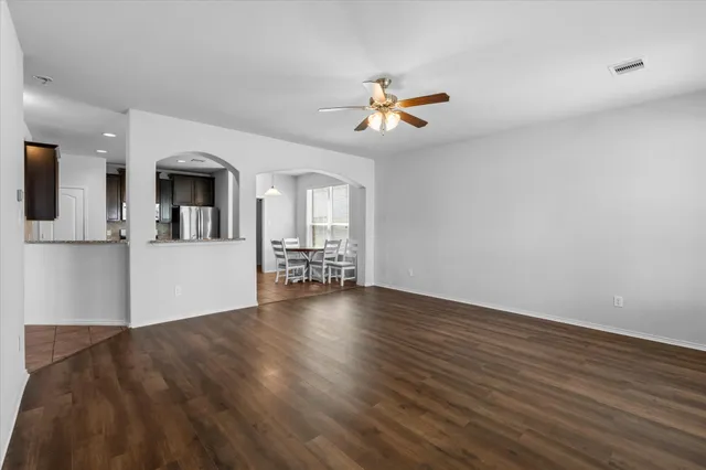 a view of a livingroom with wooden floor and a ceiling fan