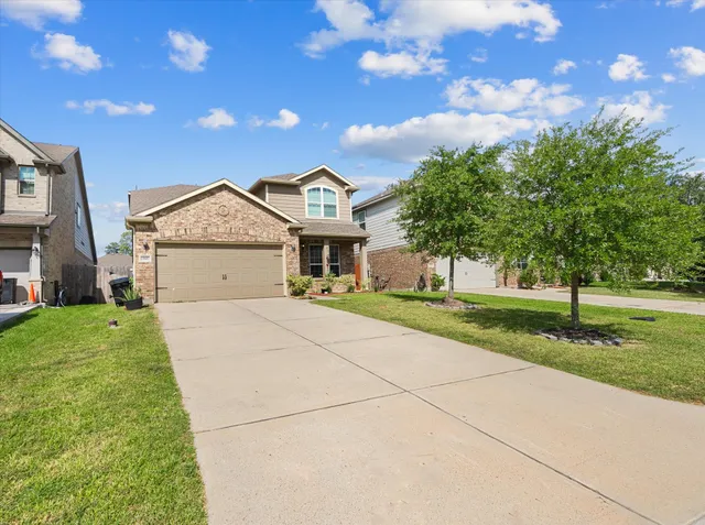 a front view of a house with a yard and garage
