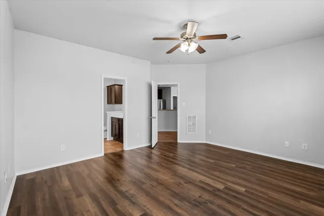 a view of an empty room with wooden floor