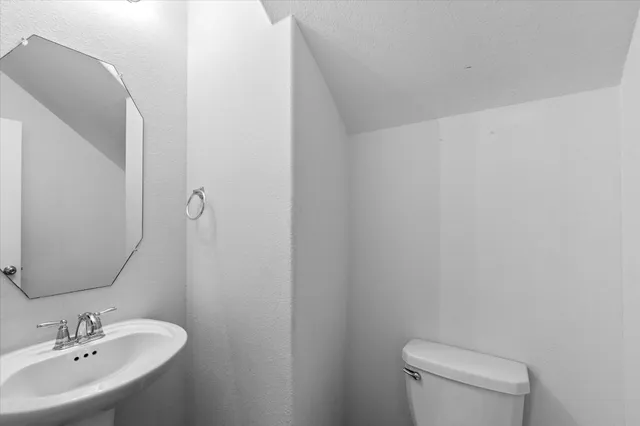 a bathroom with a toilet a sink and mirror