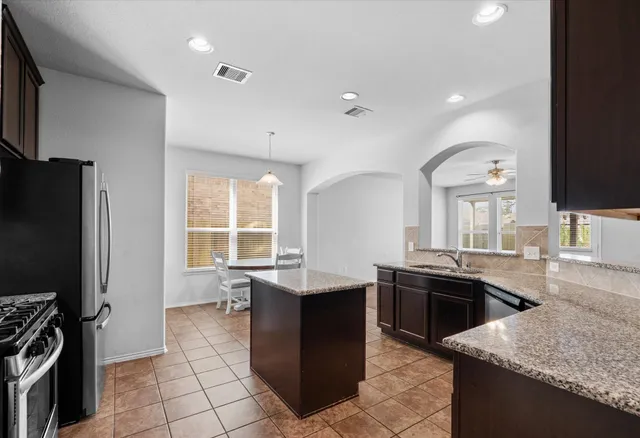 a kitchen with stainless steel appliances granite countertop a sink stove and refrigerator
