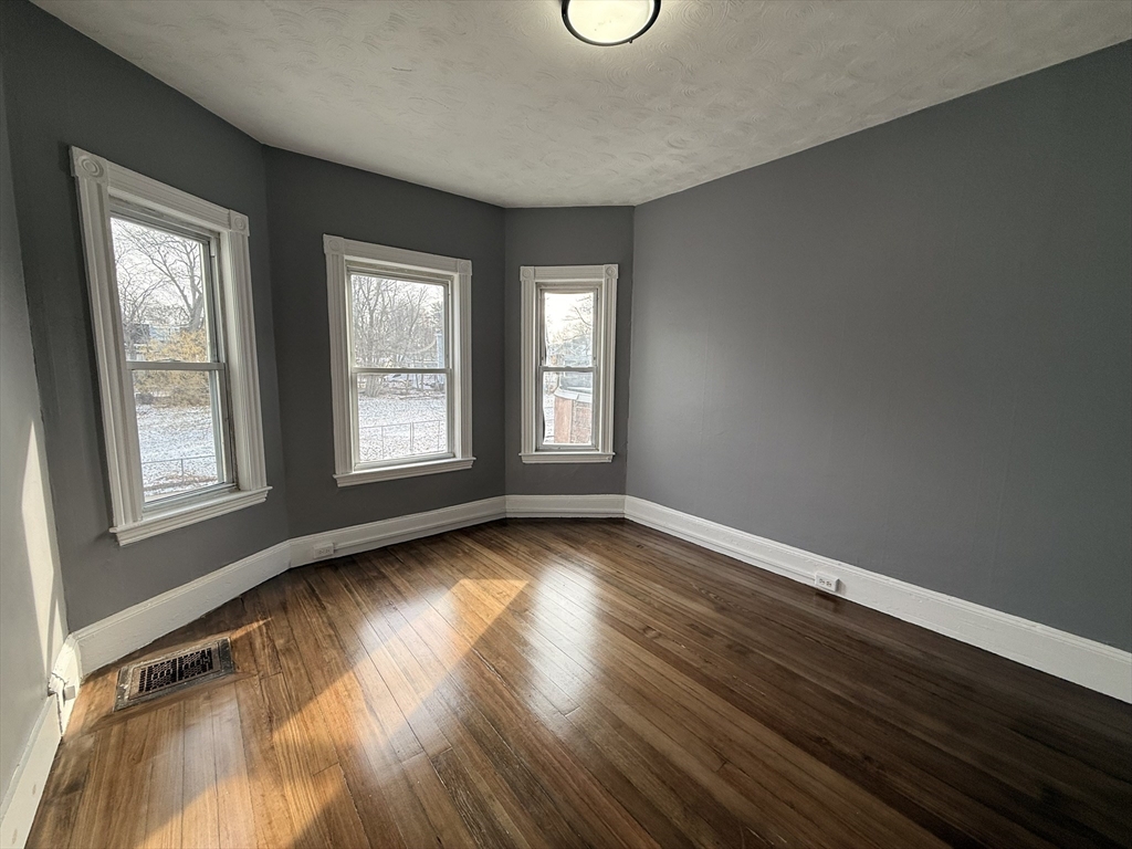 181 Norfolk Street, Unit 2 Boston, MA 02124 - Photo 10 of 18 a view of an empty room with wooden floor and window
