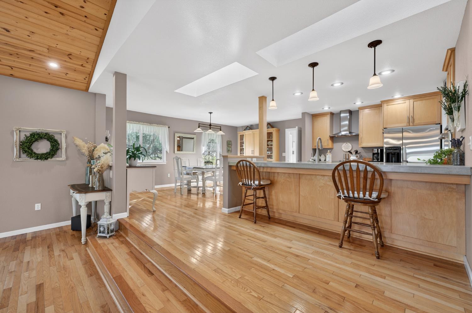 3740 Bell Road Auburn, CA 95602 - Photo 37 of 65 a kitchen with stainless steel appliances kitchen island granite countertop a table chairs in it and wooden floors