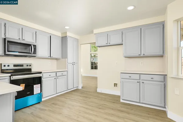a kitchen with granite countertop white cabinets and stainless steel appliances