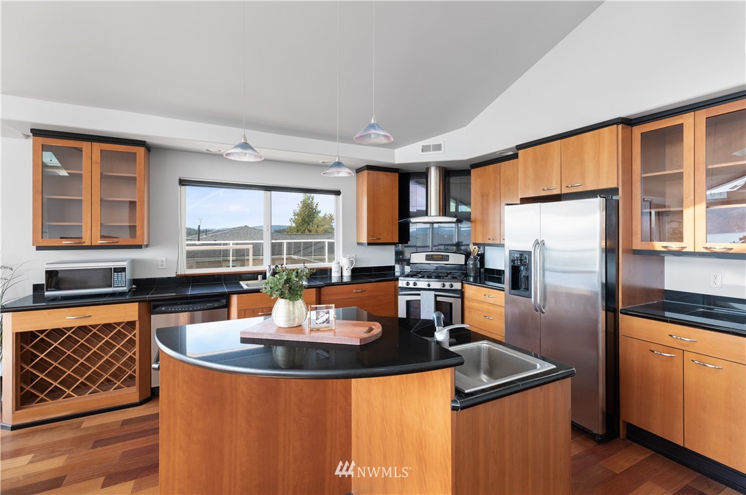 4913 Dundee Drive Anacortes, WA 98221 - Photo 17 of 40 a kitchen with stainless steel appliances granite countertop a sink a stove and refrigerator