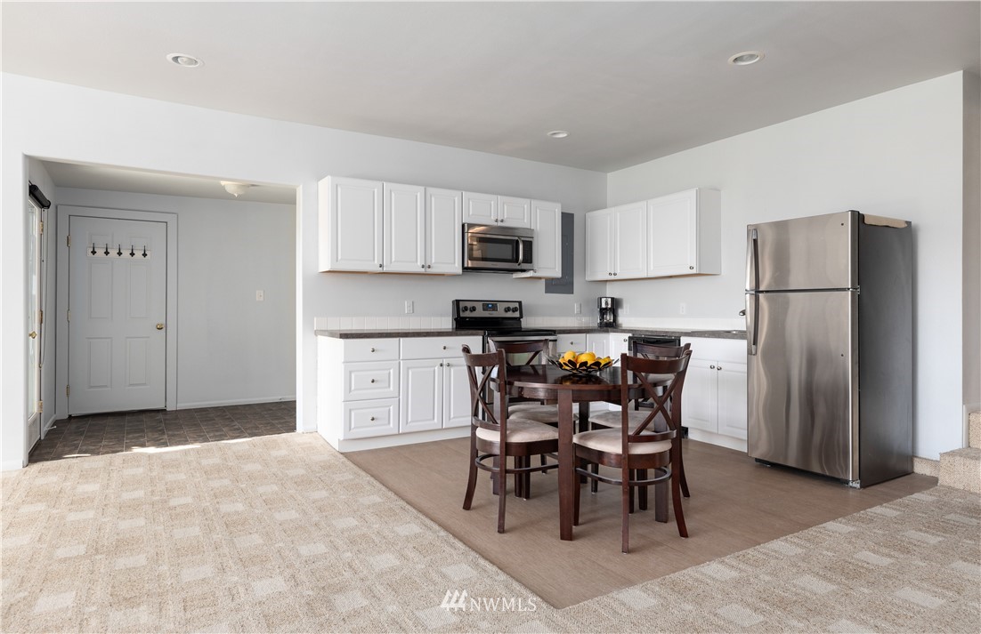4913 Dundee Drive Anacortes, WA 98221 - Photo 31 of 40 a kitchen with stainless steel appliances a refrigerator a stove a sink a dining table and chairs