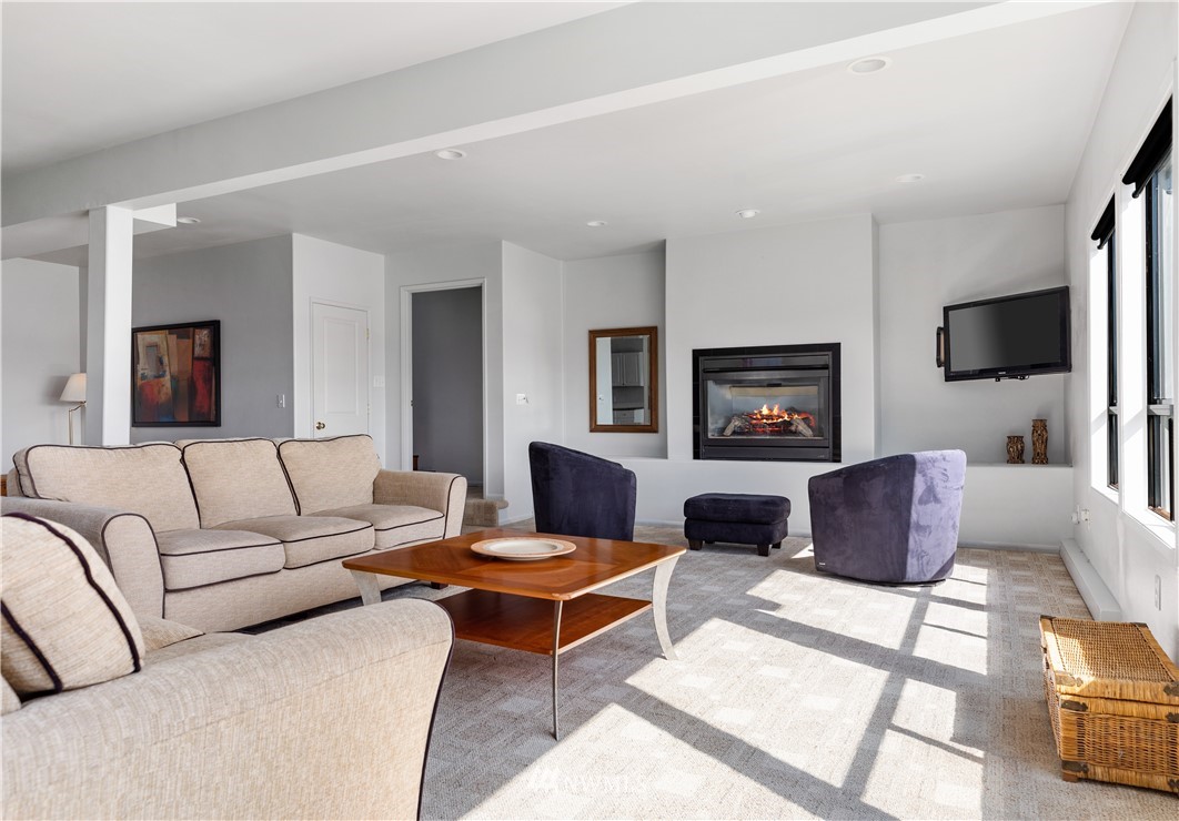 4913 Dundee Drive Anacortes, WA 98221 - Photo 32 of 40 a living room with furniture flat screen tv and a fireplace