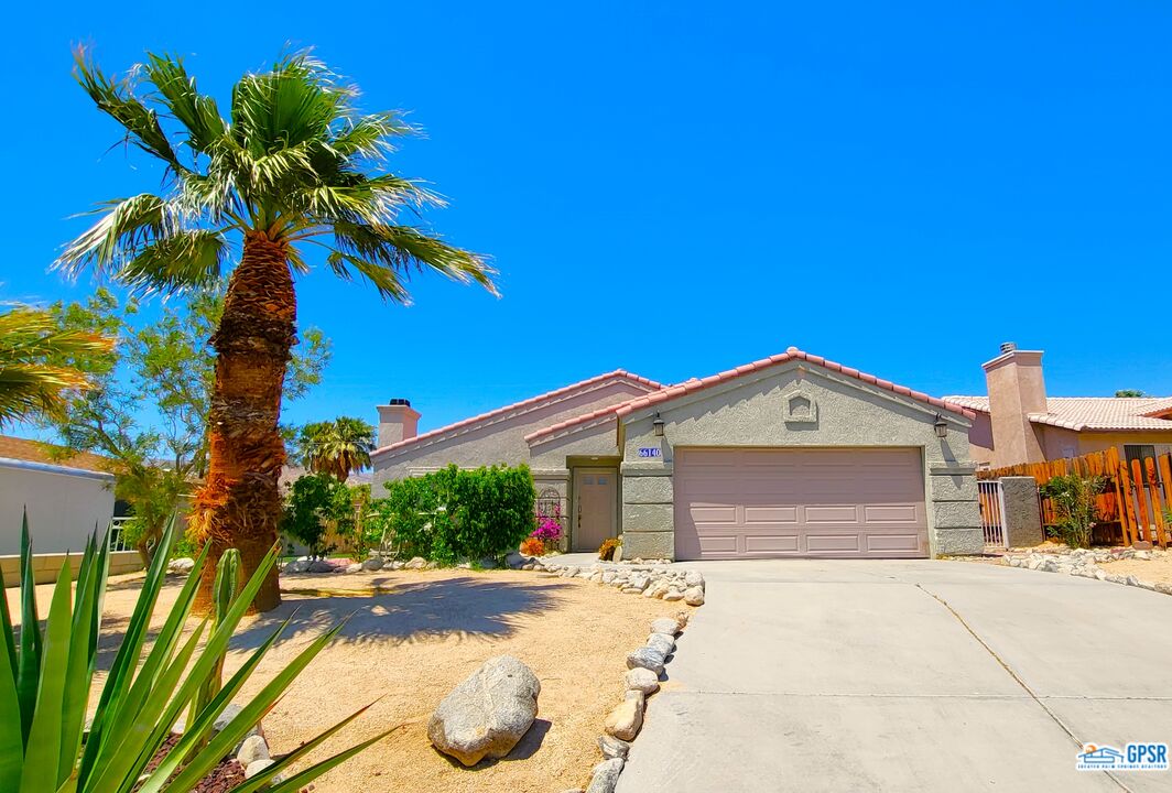 66140 Santa Rosa Road Desert Hot Springs, CA 92240 - Photo 4 of 51 a front view of a house with a yard and garage
