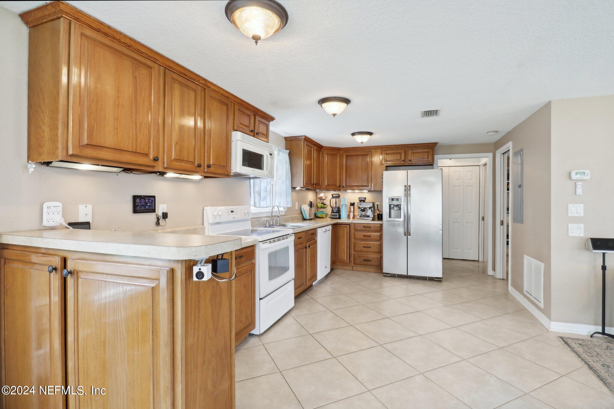 2870 Adams Road St. Augustine, FL 32092 - Photo 20 of 31 a kitchen with stainless steel appliances granite countertop a stove refrigerator sink and cabinets