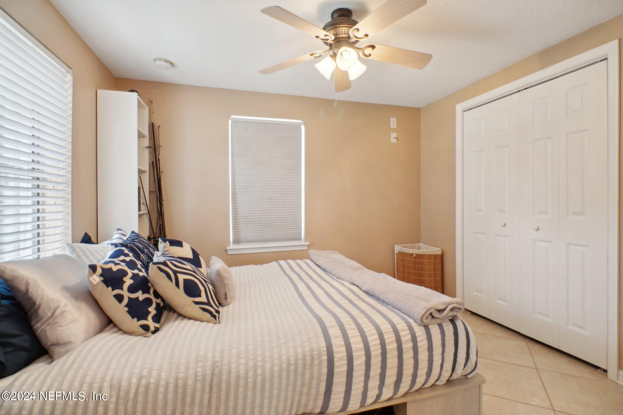 2870 Adams Road St. Augustine, FL 32092 - Photo 25 of 31 a bedroom with a bed and a chandelier