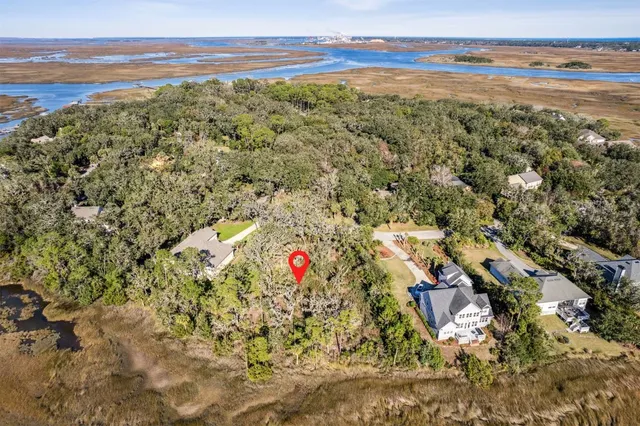 an aerial view of ocean and residential houses with outdoor space