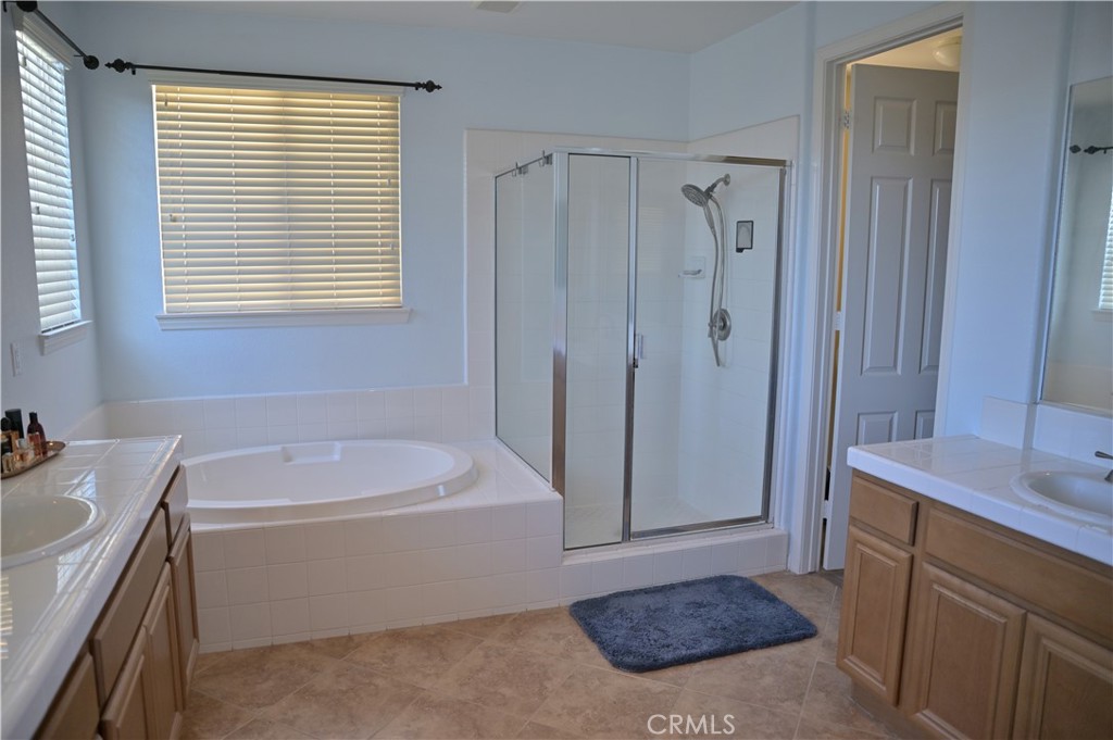7112 Acorn Place Rancho Cucamonga, CA 91739 - Photo 26 of 40 a bathroom with a tub a sink a window and a shower