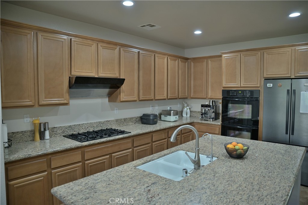 7112 Acorn Place Rancho Cucamonga, CA 91739 - Photo 9 of 40 a kitchen with stainless steel appliances granite countertop a stove a sink a refrigerator and cabinets