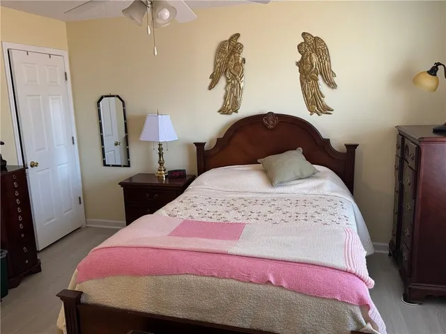 a bedroom with a bed a chandelier and dresser