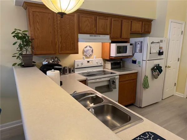 a kitchen with stainless steel appliances a sink a stove and a refrigerator with wooden floor