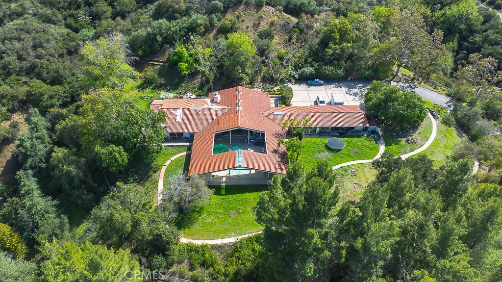 an aerial view of a house with a yard and trees