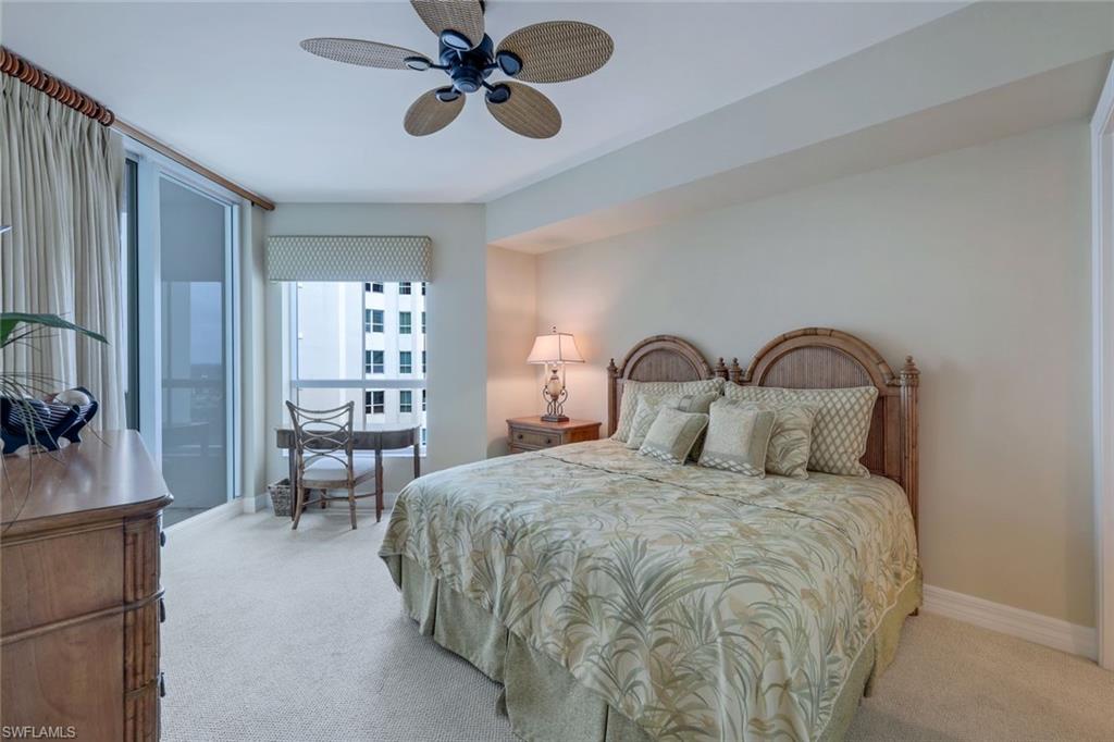 295 Grande Way, Unit 1202 Naples, FL 34110 - Photo 20 of 36 a bedroom with a bed and a chandelier