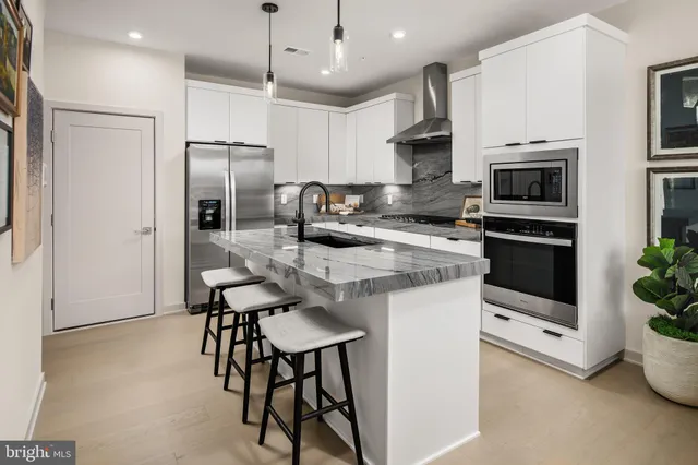 a kitchen with stainless steel appliances a stove a sink refrigerator and microwave