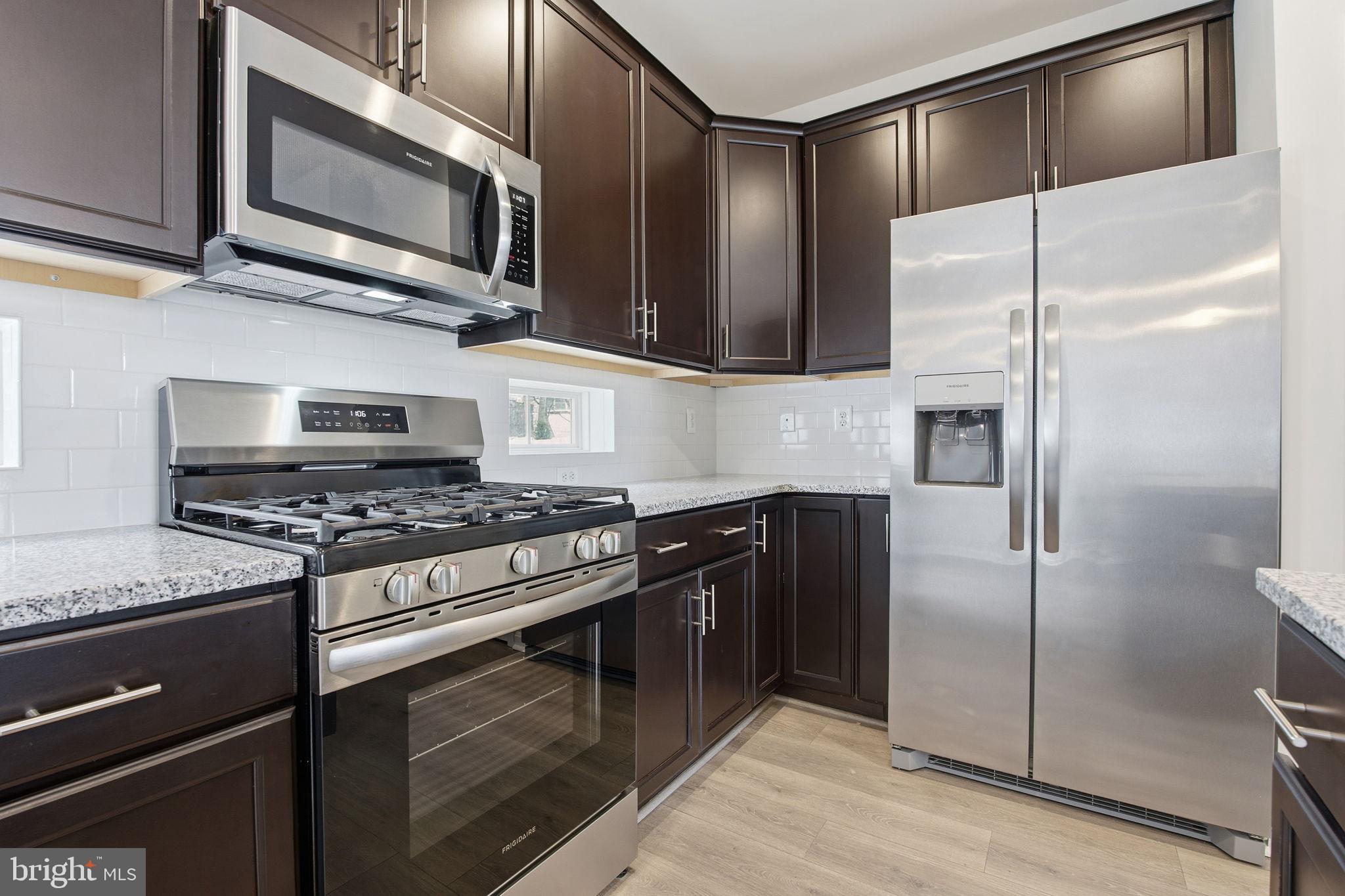 345 Tumblers Way, Unit 20 Joppa, MD 21085 - Photo 4 of 34 a kitchen with stainless steel appliances granite countertop a stove microwave and refrigerator
