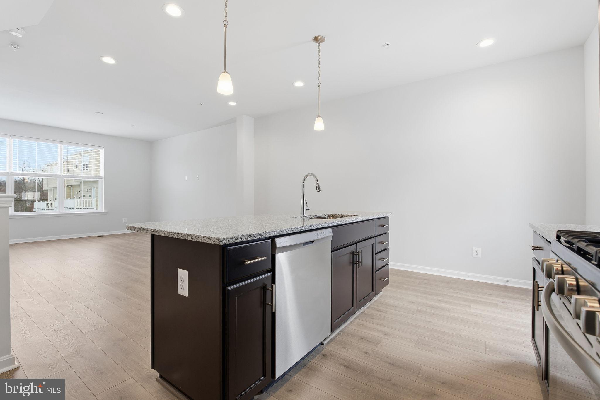 345 Tumblers Way, Unit 20 Joppa, MD 21085 - Photo 5 of 34 a kitchen with stainless steel appliances granite countertop a sink a stove and a wooden floor