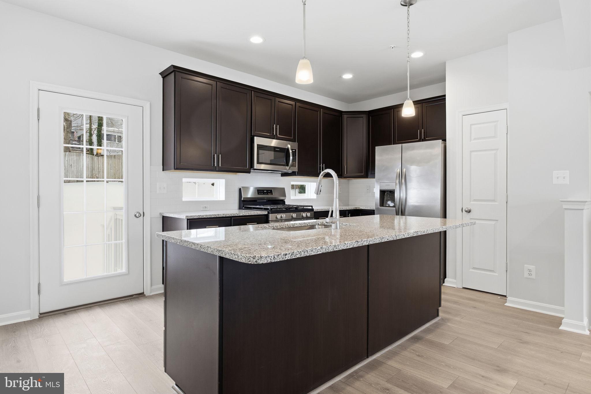 345 Tumblers Way, Unit 20 Joppa, MD 21085 - Photo 6 of 34 a kitchen with stainless steel appliances granite countertop a refrigerator a sink a stove a microwave and island