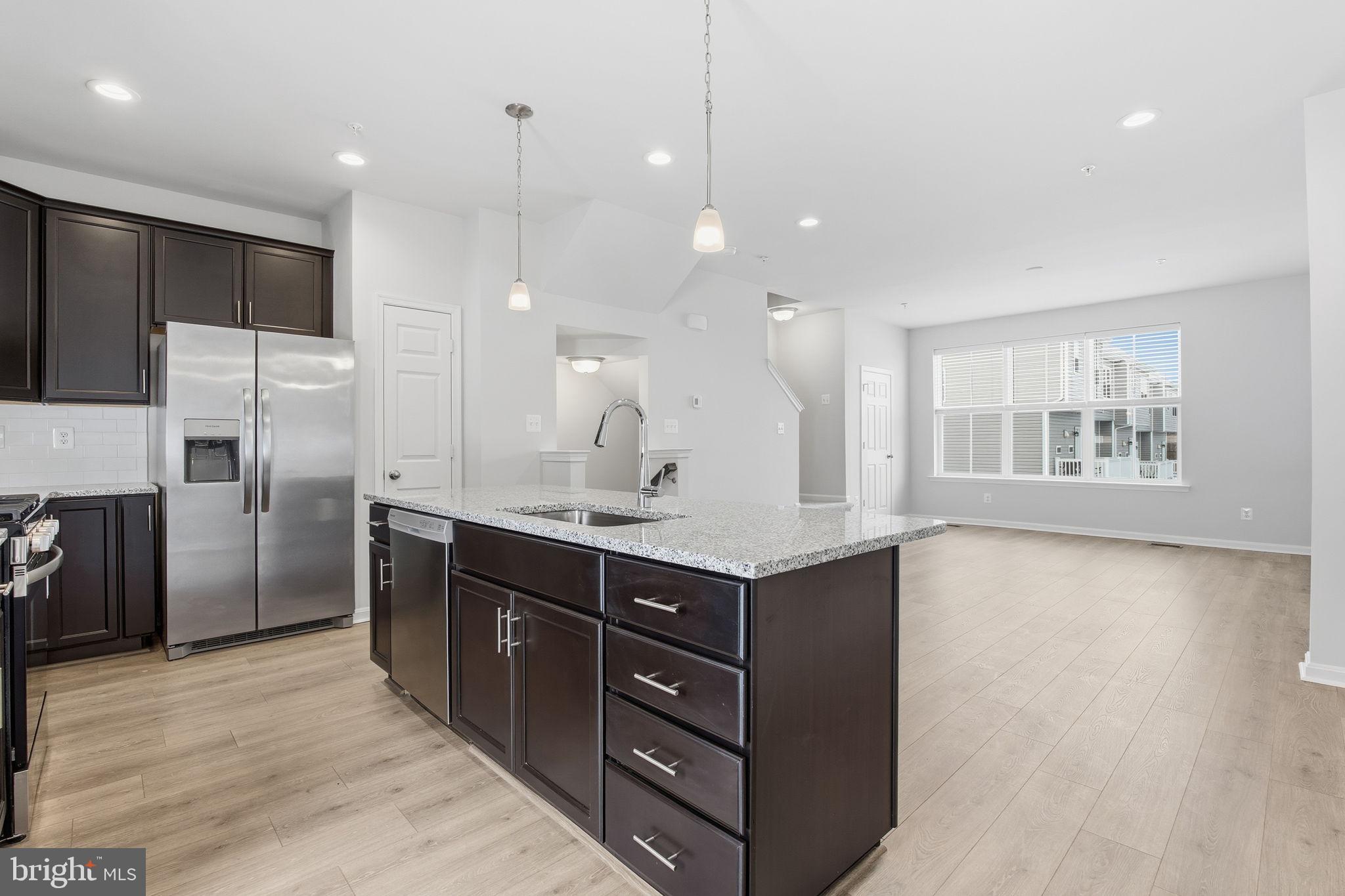 345 Tumblers Way, Unit 20 Joppa, MD 21085 - Photo 7 of 34 a large kitchen with a large counter top wooden cabinets and stainless steel appliances