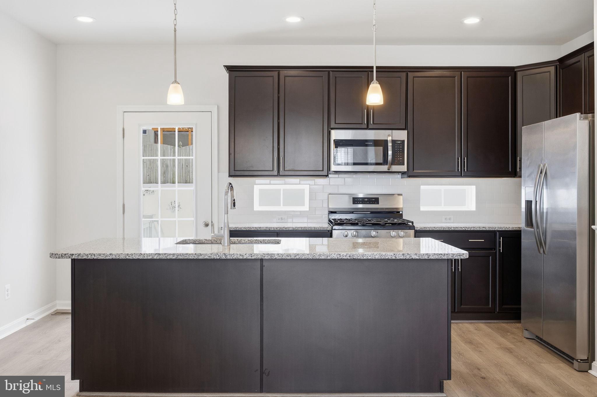 345 Tumblers Way, Unit 20 Joppa, MD 21085 - Photo 8 of 34 a kitchen with stainless steel appliances granite countertop a sink refrigerator and cabinets