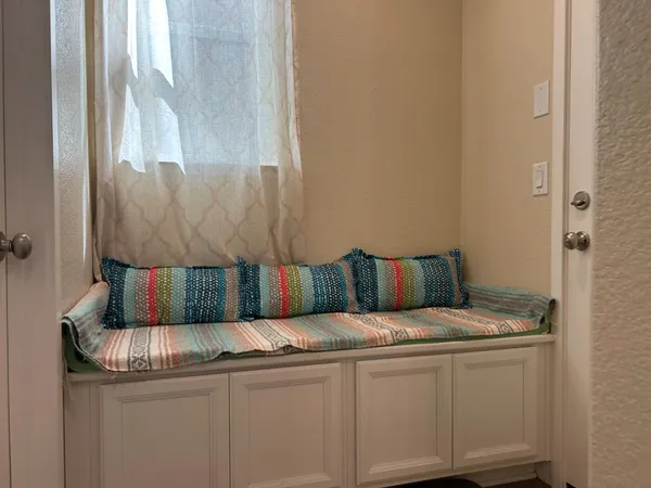 a bed sitting in a kitchen next to a window
