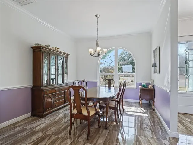 a dining room with furniture a chandelier and wooden floor