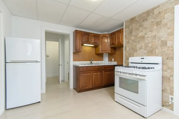 a kitchen with a stove top oven and refrigerator
