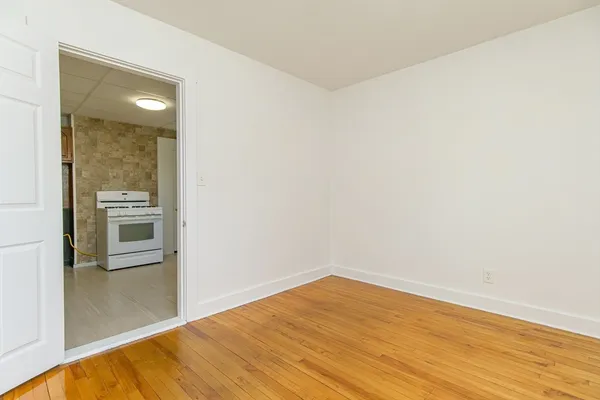 a view of empty room with wooden floor and cabinet