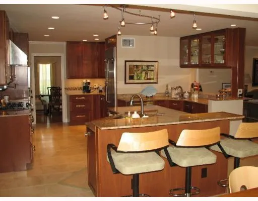 a kitchen with stainless steel appliances kitchen island granite countertop a table and chairs