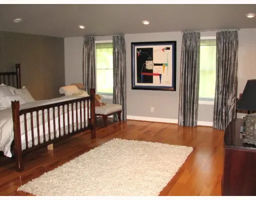 a view of a hallway with wooden floor and windows