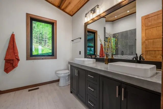 a bathroom with a granite countertop sink a toilet and shower