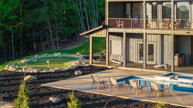 a view of a house with pool and chairs