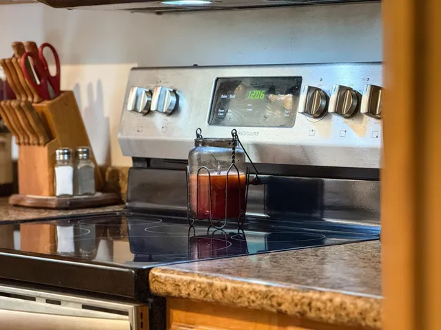 a view of kitchen with stainless steel appliances granite countertop stove top oven and cabinets