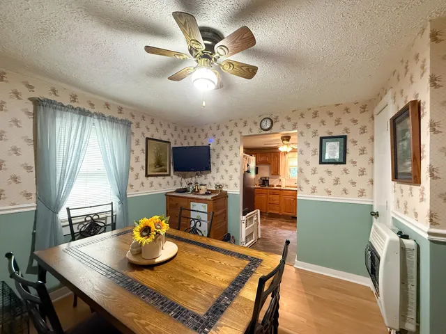 a view of a dining room with furniture a kitchen and chandelier