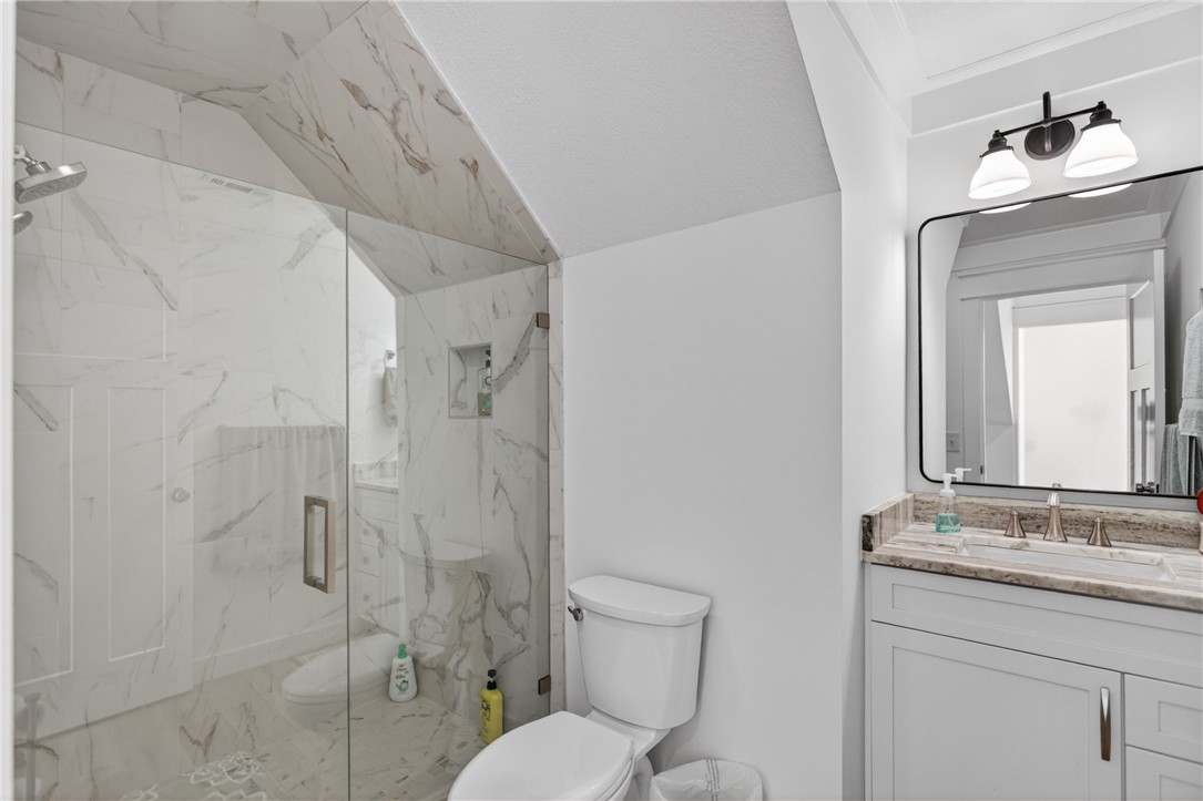 921 Falling Waters Lane Seneca, SC 29672 - Photo 33 of 46 A well-lit primary bathroom features a spacious glass-enclosed shower, complemented by an elegant vanity and modern fixtures.