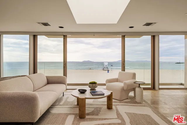 a living room with furniture and floor to ceiling window