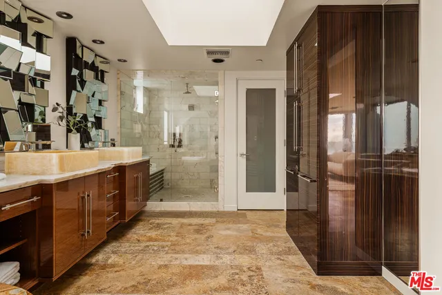 a spacious bathroom with a double vanity sink a mirror and a shower
